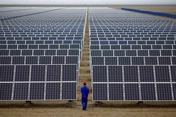 A worker inspects solar panels at a solar Dunhuang, 950km (590 miles) northwest of Lanzhou, Gansu Province in this September 16, 2013 file photo. REUTERS/Carlos Barria/Files