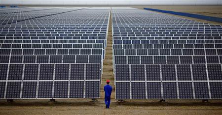 A worker inspects solar panels at a solar Dunhuang, 950km (590 miles) northwest of Lanzhou, Gansu Province in this September 16, 2013 file photo. REUTERS/Carlos Barria/Files