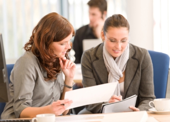 Business meeting - group of people in office sitting at computer desk