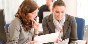 Business meeting - group of people in office sitting at computer desk