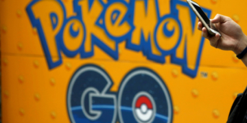 A man uses a mobile phone in front of an advertisement board bearing the image of Pokemon Go at an electronic shop in Tokyo, Japan, July 27, 2016.   REUTERS/Kim Kyung-Hoon/File Photo