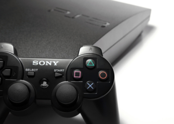 Indianapolis, Indiana, USA - March 23rd, 2011: A 120GB slim version of Sony's Playstation 3 sits isolated on white with one of the system's wireless controllers placed up against the console.