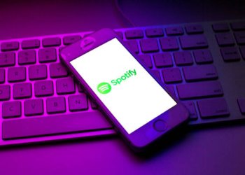SPAIN - 2021/10/13: In this photo illustration a Spotify logo seen displayed on a smartphone on top of a computer keyboard. (Photo Illustration by Thiago Prudencio/SOPA Images/LightRocket via Getty Images)