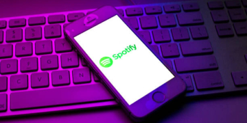 SPAIN - 2021/10/13: In this photo illustration a Spotify logo seen displayed on a smartphone on top of a computer keyboard. (Photo Illustration by Thiago Prudencio/SOPA Images/LightRocket via Getty Images)