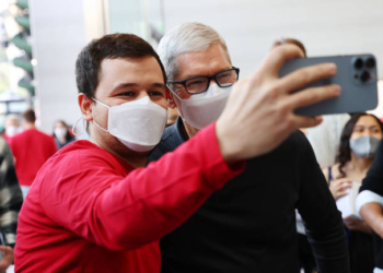 LOS ANGELES, CALIFORNIA - NOVEMBER 19: Apple CEO Tim Cook (R) poses for a selfie with a person at the grand opening event for the new Apple store at The Grove on November 19, 2021 in Los Angeles, California. The original Apple store in The Grove was opened in 2002 but was redesigned in a new location with twice the space and opened today in time for the holiday shopping season. (Photo by Mario Tama/Getty Images)