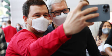 LOS ANGELES, CALIFORNIA - NOVEMBER 19: Apple CEO Tim Cook (R) poses for a selfie with a person at the grand opening event for the new Apple store at The Grove on November 19, 2021 in Los Angeles, California. The original Apple store in The Grove was opened in 2002 but was redesigned in a new location with twice the space and opened today in time for the holiday shopping season. (Photo by Mario Tama/Getty Images)