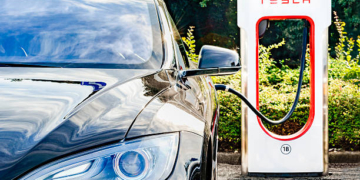 Zevenaar, The Netherlands - September 10, 2015: Black Tesla Model S electric car at a Tesla supercharger charging station. Superchargers are free connectors that charge Model S in minutes. Superchargers are used for long distance travel, located along the most popular routes in North America, Europe and Asia.