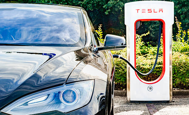 Zevenaar, The Netherlands - September 10, 2015: Black Tesla Model S electric car at a Tesla supercharger charging station. Superchargers are free connectors that charge Model S in minutes. Superchargers are used for long distance travel, located along the most popular routes in North America, Europe and Asia.